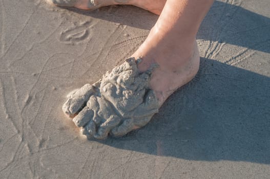Person playing in the sand on a beach in The Strand, South Africa at sunset