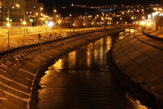 River embankment, illuminated by lights at night
