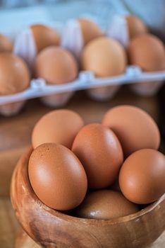 Fresh eggs at wooden plate closeup