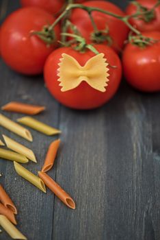 food background on rustic wood with pasta and tomatoes