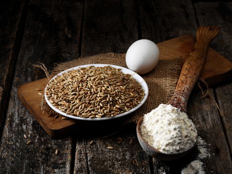 rye grain, egg, flour on the old wooden table