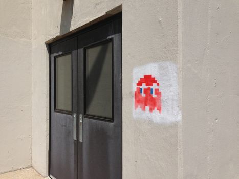 Image of a red Pac Man style graffiti or tag outside of a building.