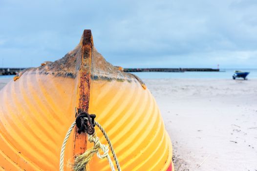 Wooden boat inverted bottom up on the sandy beach