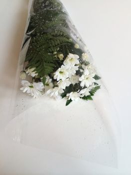 White daisy flowers with greenery wrapped in celephane 