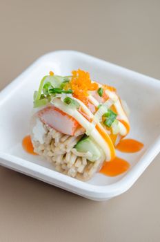 Salmon roll sushi with shrimp egg on top in white dish
