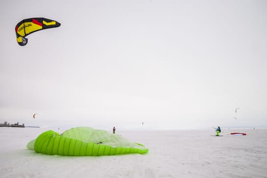 Kite surfer being pulled by his kite across the snow