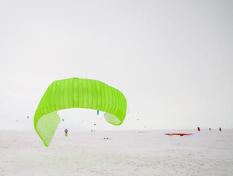 Kite surfer being pulled by his kite across the snow