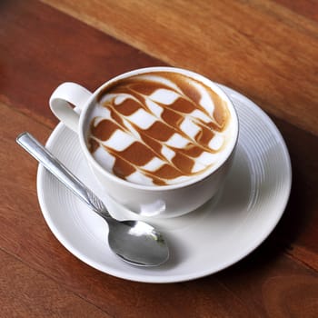 Cup of latte coffee on the wooden desk