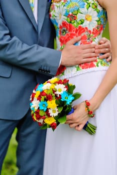 Colorful wedding bouquet in hands of the bride.