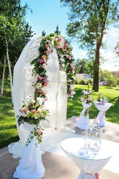 Decorated archway for wedding ceremony with colorful flowers and ribbons 