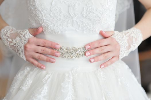 Hands bride with a manicure, on the finger of the bride wedding.