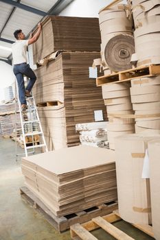 Full length of a warehouse worker loading up pallet