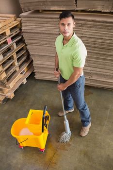 Portrait of man moping warehouse floor