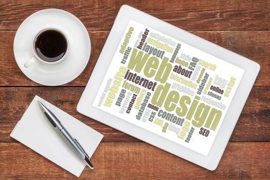 web design word cloud on a digital  tablet with a cup of coffee on a rustic wooden table