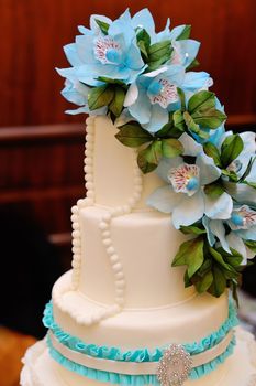 Detail of wedding cake on table with blue flowers