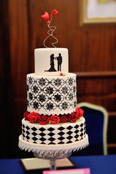 Wedding cake with two hearts and red flowers