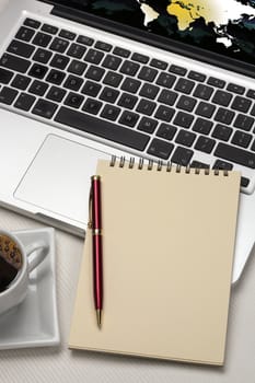 Computer laptop and a blank notepad and pen with space for text.