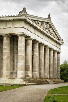 Image of the Walhalla in Bavaria Germany with green meadow and dark clouds