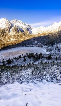 Vertical panoramic view of winter mountains, lake and cottage, High Tatras, Slovakia
