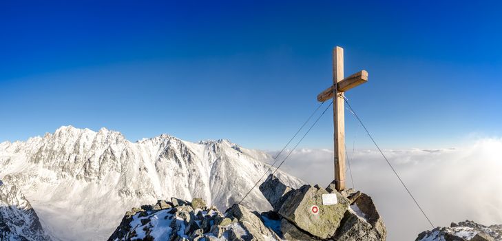 Scenic view of winter mountains peak with cross, High Tatras, Slovakia, Europe