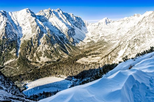 Scenic landscape view of winter mountains, lake and cottage, High Tatras, Slovakia