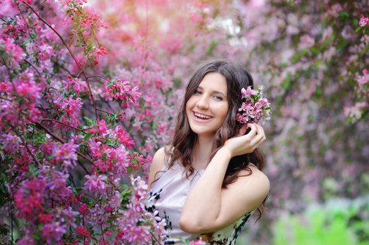 beautiful smiling brunette in the flowered garden.