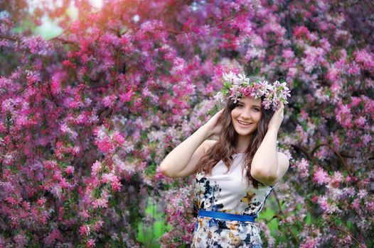 Beautiful girl outdoors spring portrait, young woman with flowers in green park, spring concept. cheerful teenager walking outdoor. series in portfolio