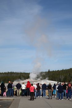 Visitors to Yellowstone National Park await the eruption of Old Faithful geyser.