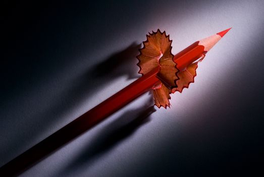 Red pencil and shaving (on a dark background).
It is a metaphor - fast career.