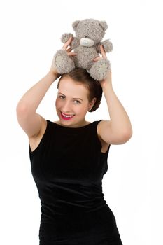 attractive smiling brunette holding teddy bear in a black dress and smiling