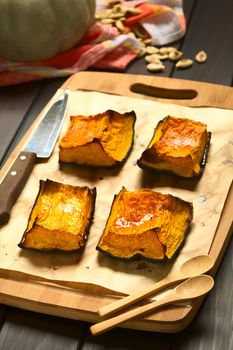 Baked pumkin pieces with caramelized sugar on top, a traditional autumn snack in Hungary, photographed with natural light (Selective Focus, Focus on the front of the first pieces)