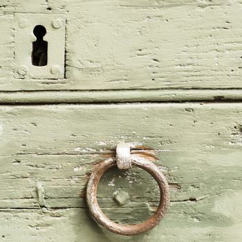 Detail embossed metal handle and keyhole of an ancient door