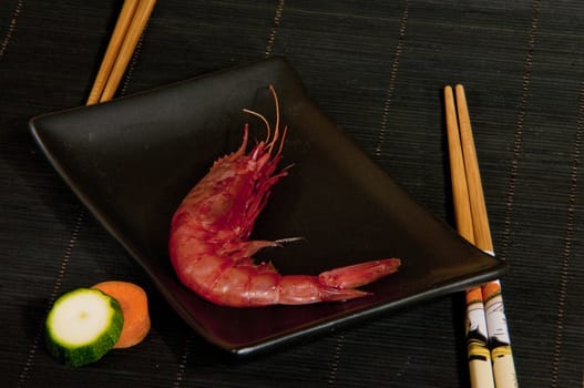 red fresh shrimp on a fork with black background