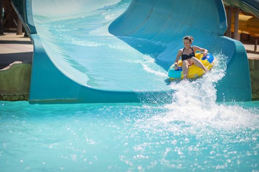 beautiful girl pulls off the slides at the water park.
