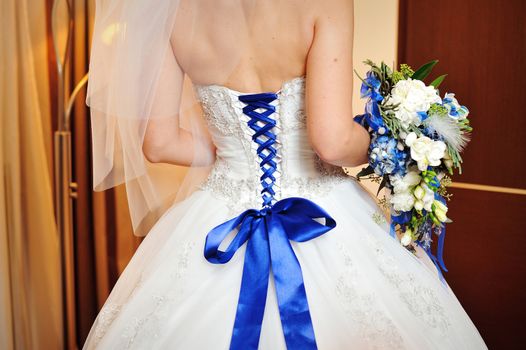 Fashion model wearing wedding dress at black studio background.