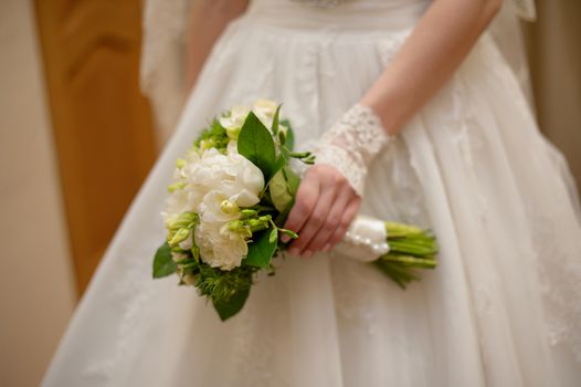 Bride holding white wedding bouquet of roses and love flower.