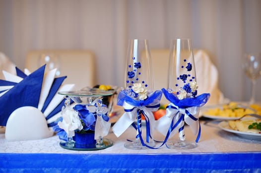 Two glasses and candle on served celebratory table.