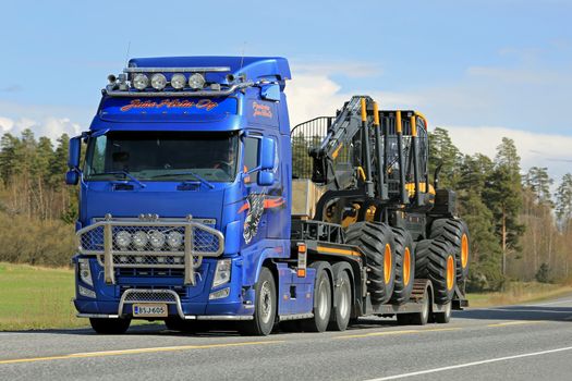 KAARINA, FINLAND - MAY 2, 2014: Volvo FH truck hauls Ponsse Scorpion forest harvester.  According to Q1 2015, Ponsses net sales amounted to EUR 91.2 million. 