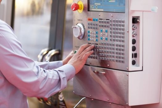 Hand on the control panel of a programmable machine