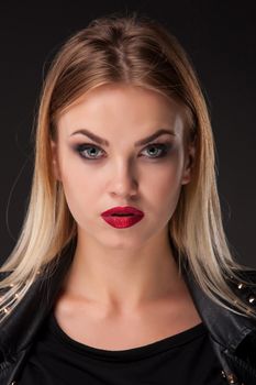 Close-up portrait of beautiful model with long blond hair on black background