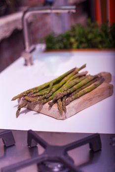 View of bunch of fresh asparagus on cutting board