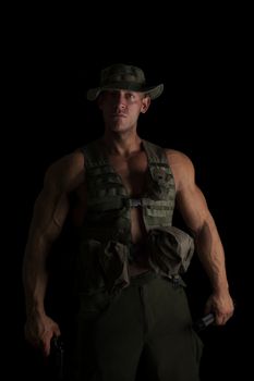 Serious soldier with gun and flashlight isolated on black background. War on terror.