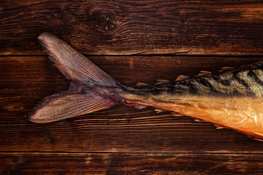 Smoked mackerel on wooden background top view. Culinary seafood background, country vintage styles.