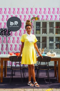 MILAN, ITALY - APRIL 16: Pretty young black girl in the kitchen room at Buru-buru stand in the Tortona space location during Milan Design week on April 16, 2015