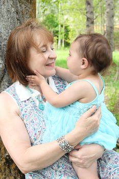 Grandmother and grandaughter sitting outside in the field