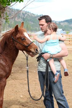 Father and daughter spending time with their horse