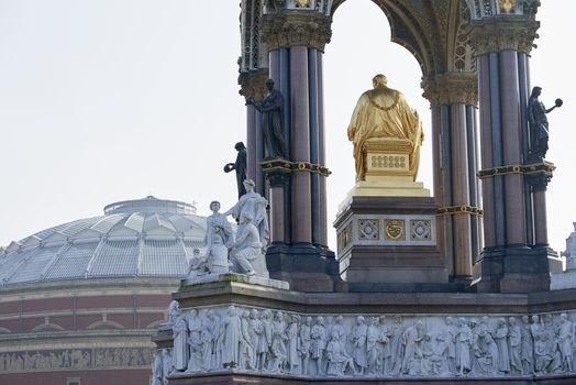 Albert Memorial statue overlooking hazy Royal Albert Hall, in London. The memorial was commissioned by Queen Victoria in memory of her husband, who died in 1861.