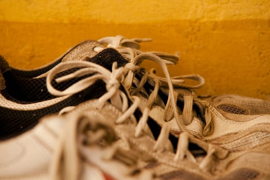 sneakers in a row with laces on the yellow background