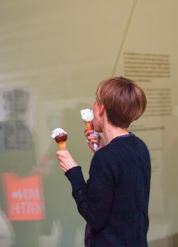 MILAN, ITALY - APRIL 16: Girl eating two icecream during Milan Design week on April 16, 2015