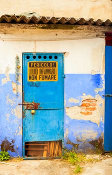 View of blue iron door with dangerous sign